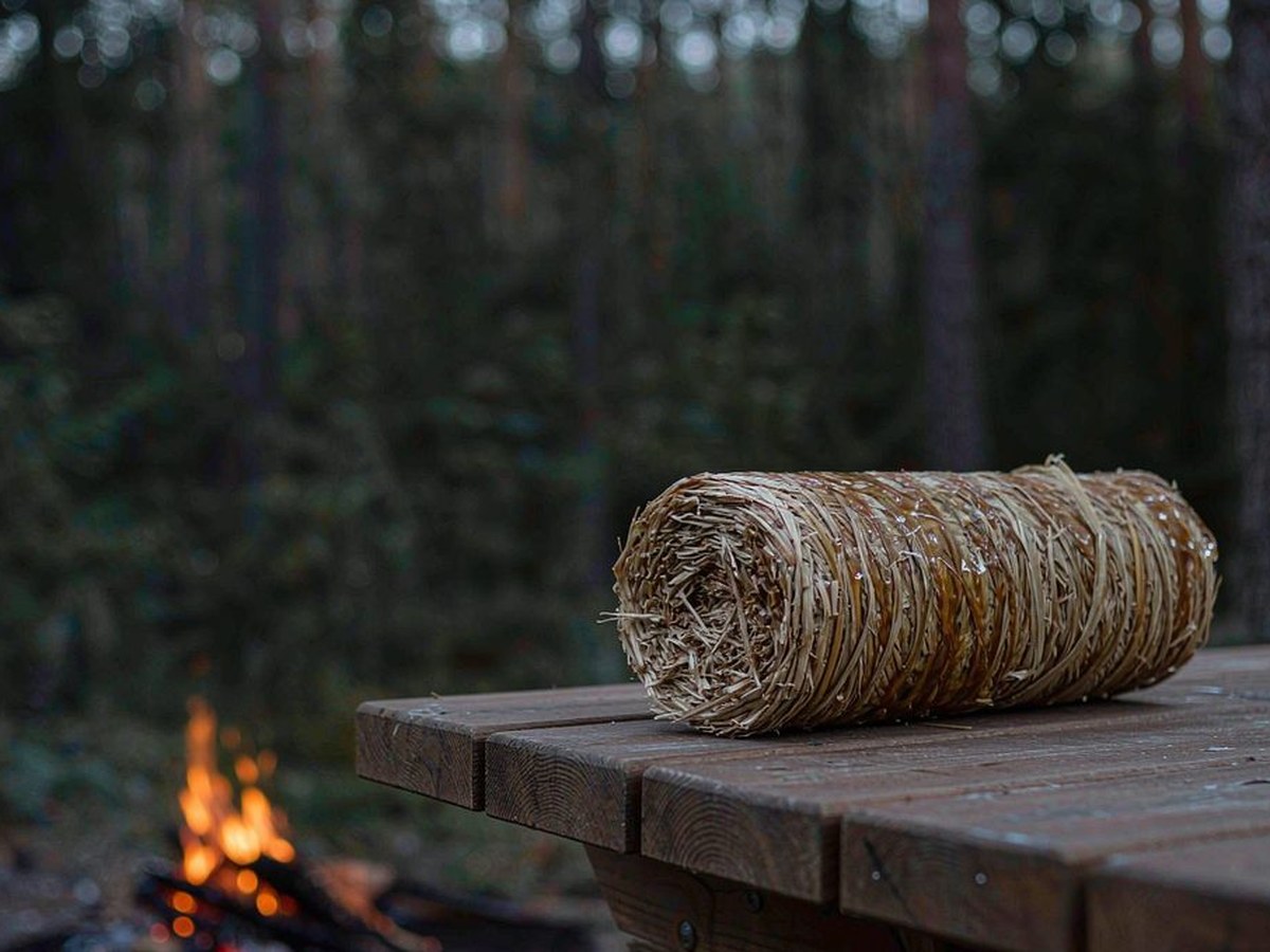 Classic fire starter roll on a picnic table beside a campfire ring at dusk