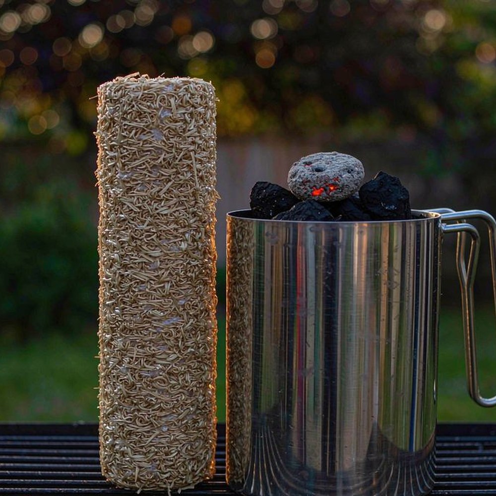Long burn wood wool fire starter roll beside a charcoal chimney starter on a grill