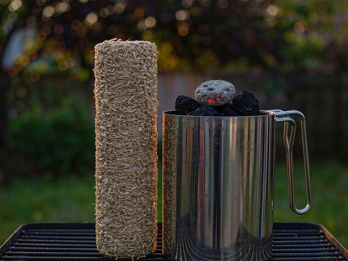 Long burn fire starter roll and a charcoal chimney starter full of briquettes on a garden grill